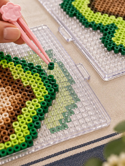 Close view of the fuse bead pickup tool, beads, pattern, and clear pegboard