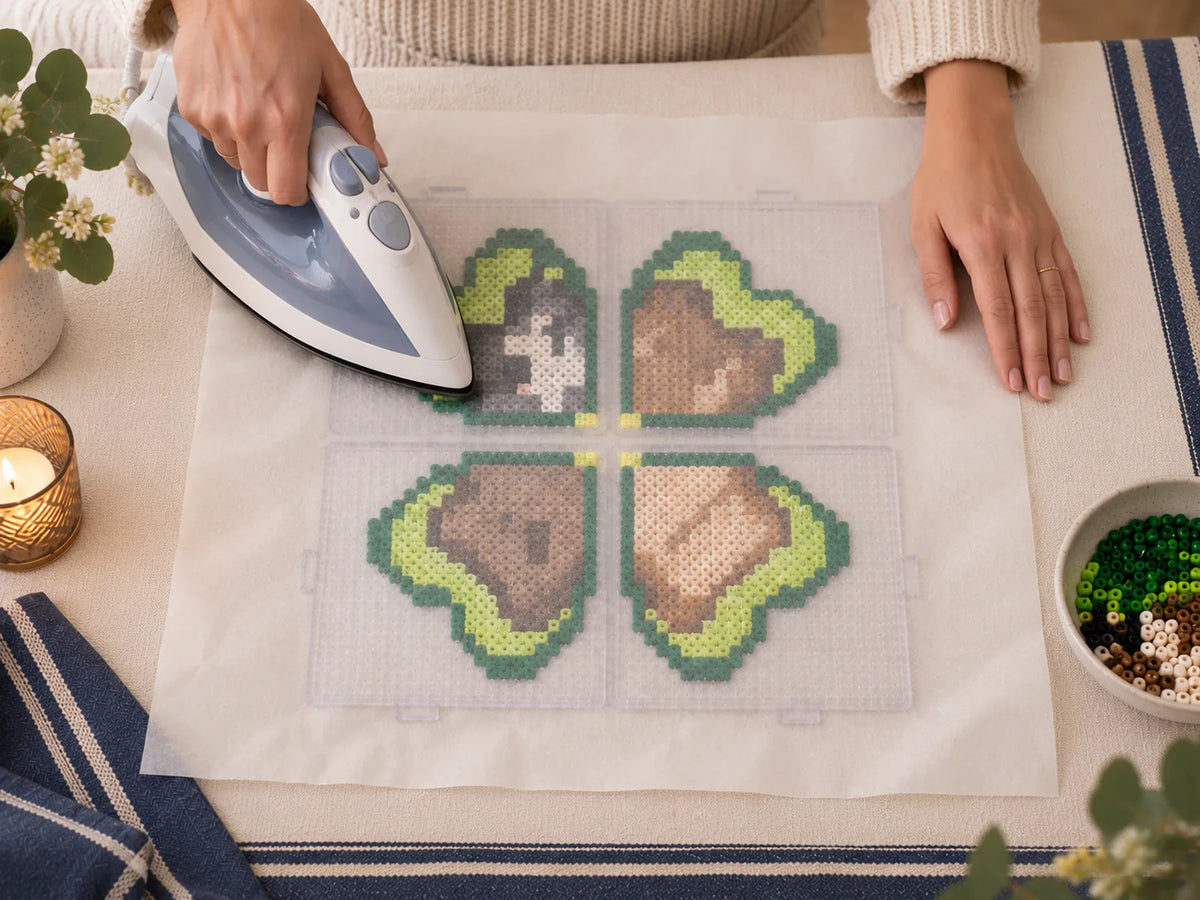 Adult fusing the finished bead artwork under protective ironing paper